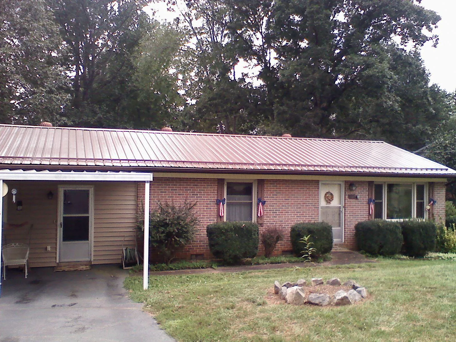 Bronze metal roof and carport on a brick ranch home — Roof Repair work by our crew in Lawrenceburg