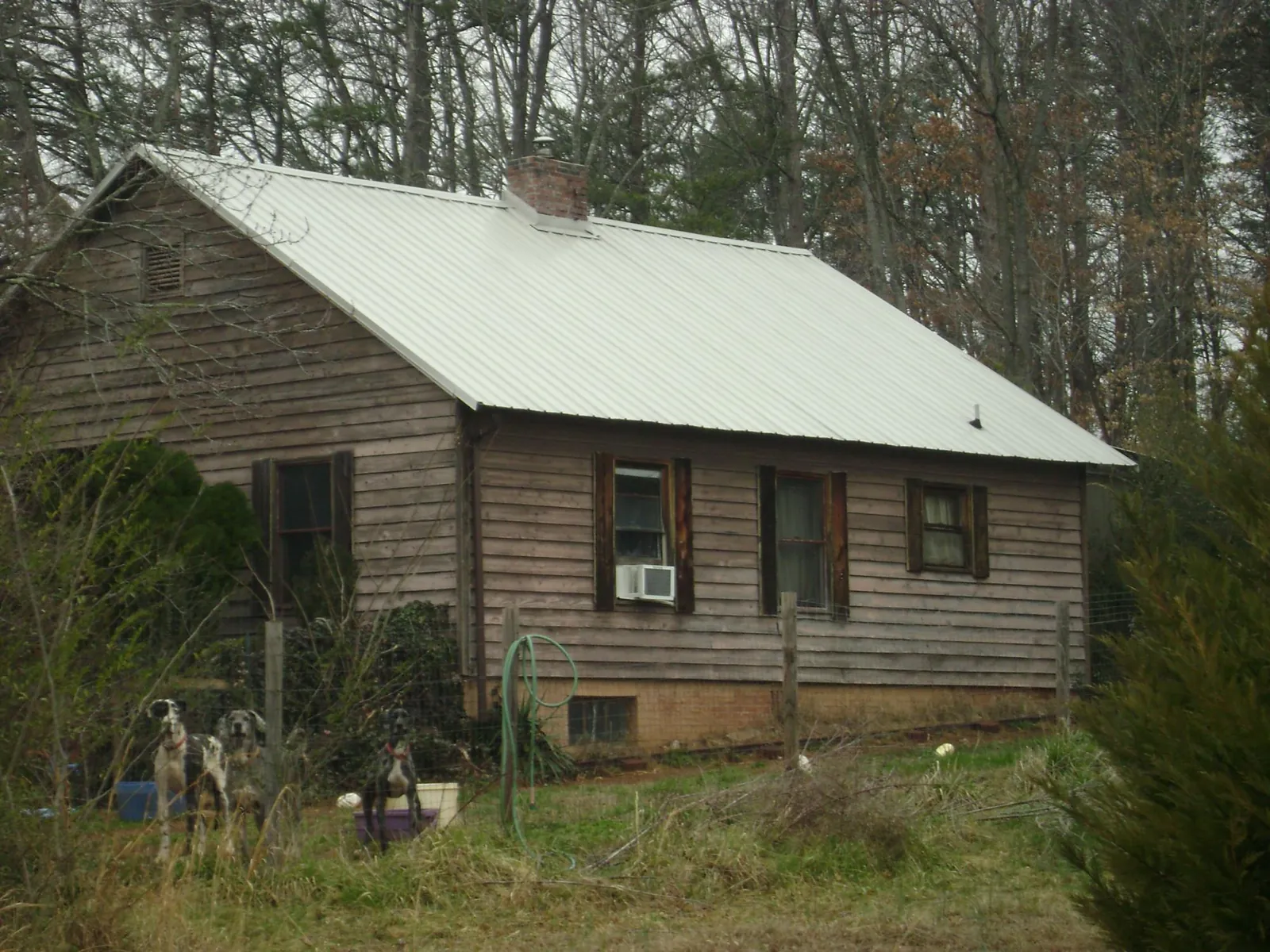White metal roof on an old wood sided farmhouse, from a Metal Roof Installation job in Lawrenceburg